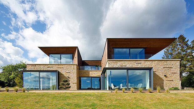 Curtain walls and lift-and-slide doors installed within a contemporary residential setting